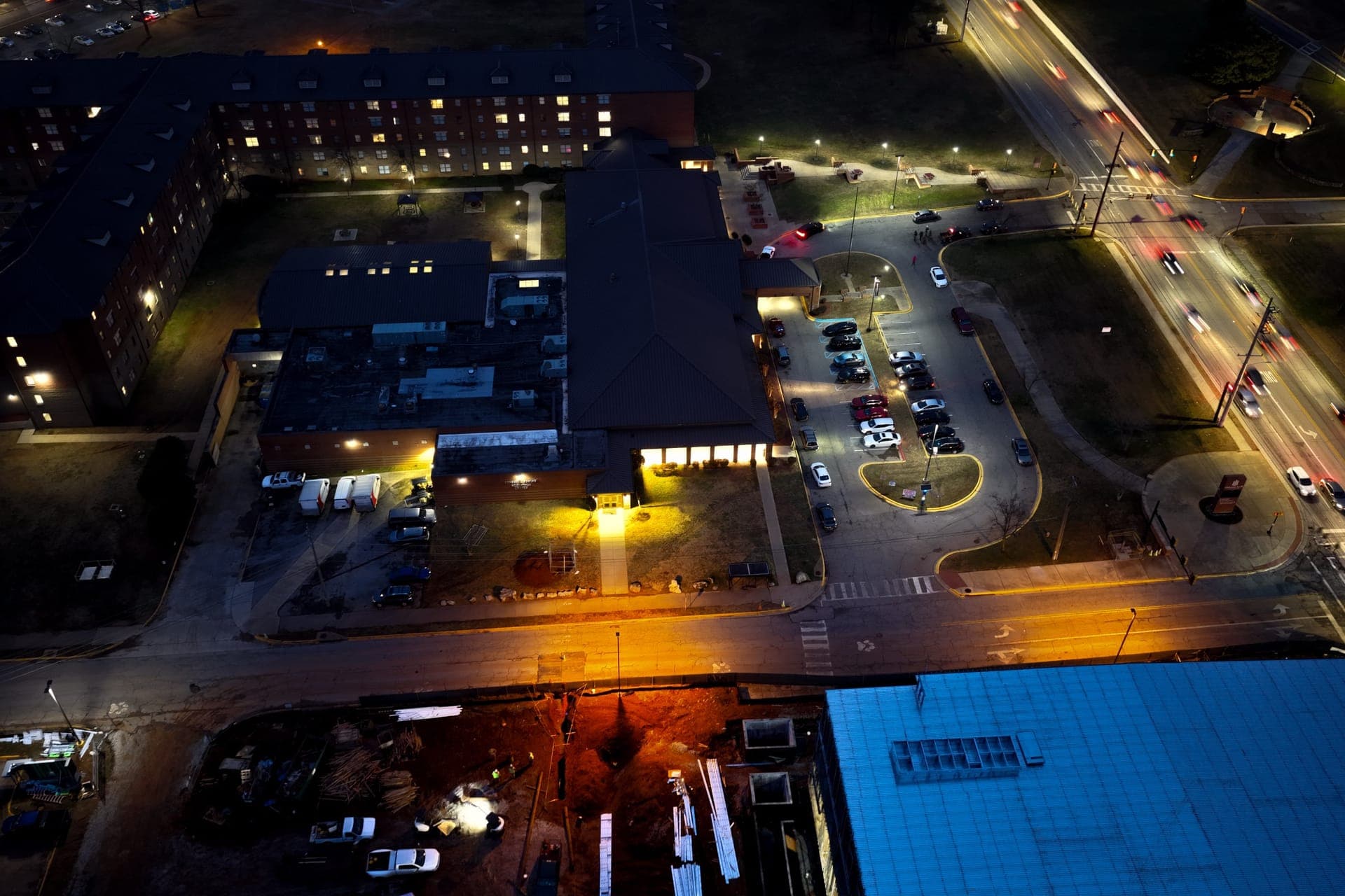 A commercial property at night from above, parking and building exterior lit after an Energie project
